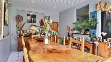 Un'ampia sala da pranzo con un lungo tavolo in legno, sedie e un elemento decorativo al centro.
