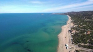 Oversigtsbillede af et kystområde med strand og tilstødende boliger.