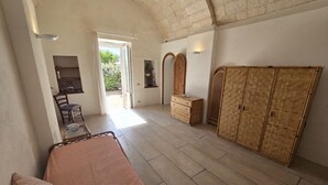 A bedroom with a bed, a dresser, a wardrobe, a chair, and a small table.