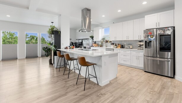 A modern kitchen with a large island, white cabinets, stainless steel appliances, and a view of the outdoors. - Spacious 4-bedroom house with fitness room, sauna, hot tub in vibrant Denver (Denver)