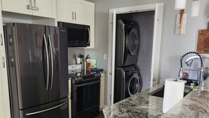 Een moderne keuken met roestvrijstalen apparatuur, een granieten aanrechtblad en een inbouwoven.
