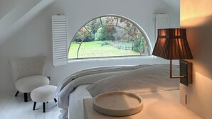 A bedroom with a skylight, a chandelier, a bed, a chair, and a lamp. - Elegant Hampshire Countryside Stay, Petersfield (Petersfield)