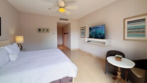 A hotel room with a bed, a desk, a chair, a television, and a ceiling fan. - Tropical Garden Retreat 2BR in Plaza Puntarena (Río Hato)