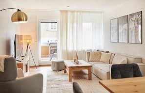 Ein modernes Wohnzimmer mit einer Couch, einem Couchtisch und einer Lampe.