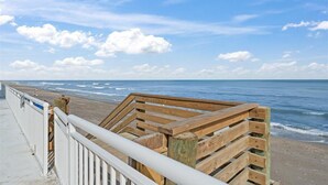 A wooden boardwalk leading to a beach with a clear sky and calm sea. - Salt Life Oasis - Direct Oceanfront, End Unit in Satellite Beach, FL (Satellite Beach)
