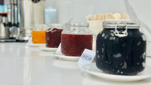 Esposizione di diverse marmellate su piatti con etichette.