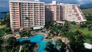 Ein Hotel mit mehreren Hochhäusern, einem Schwimmbad und üppiger Bepflanzung.