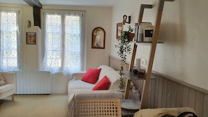 Ein gemütliches Wohnzimmer mit einer Couch, einem kleinen Tisch und einer Heizung.