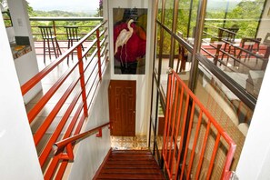 A staircase with red railings leading to a balcony with a view of greenery. - SauGaLe - Near Chirripó, King Bed, Pool & Hot Tub (Pérez Zeledón)
