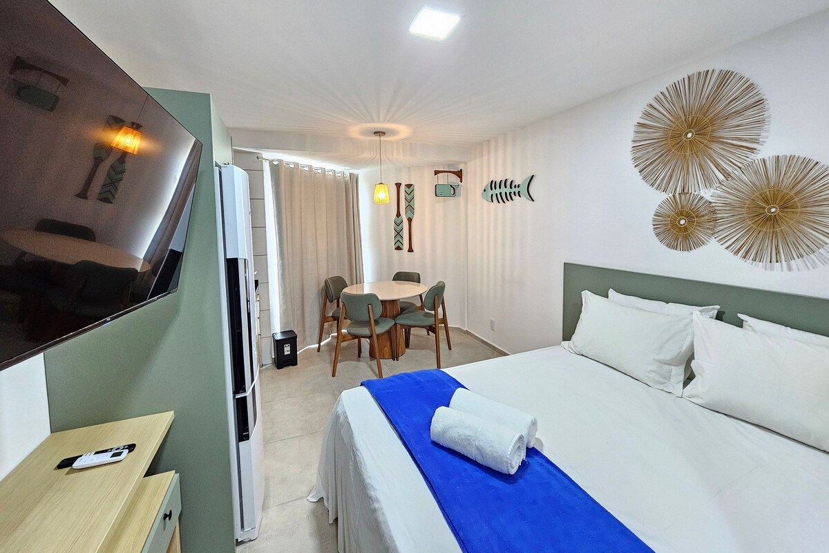Une chambre d’hôtel comprenant un lit, une télévision, un bureau et un coin repas.