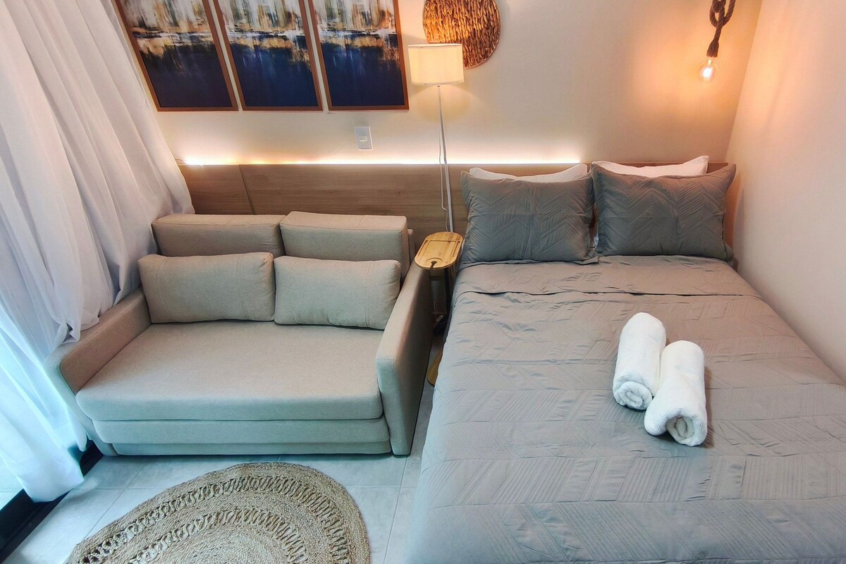 Ein gemütliches Hotelzimmer mit Bett, Schlafsofa, kleinem Tisch und Lampe.