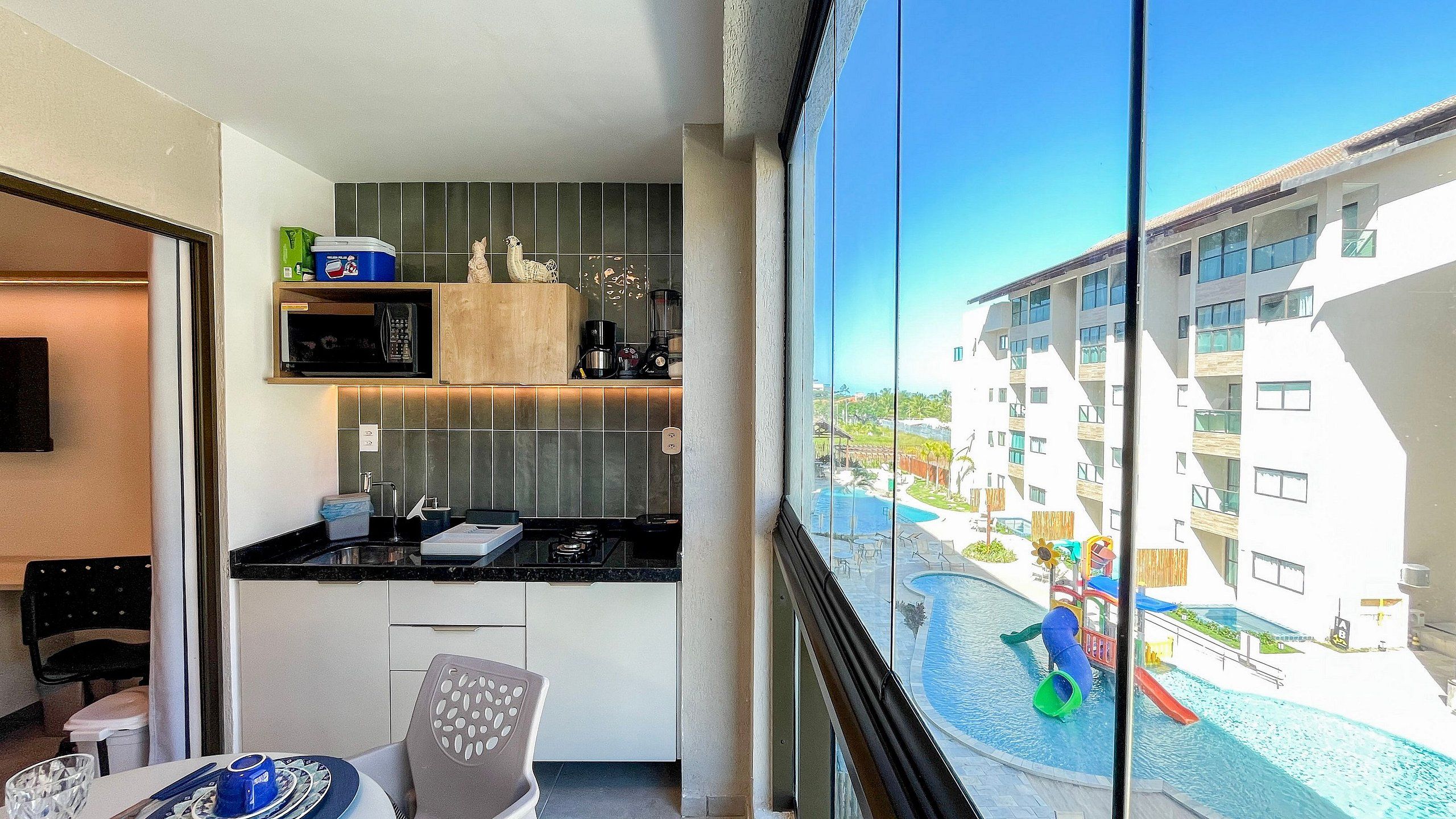 Eine moderne Küche mit Blick auf einen Swimmingpool und ein Wohngebäude.
