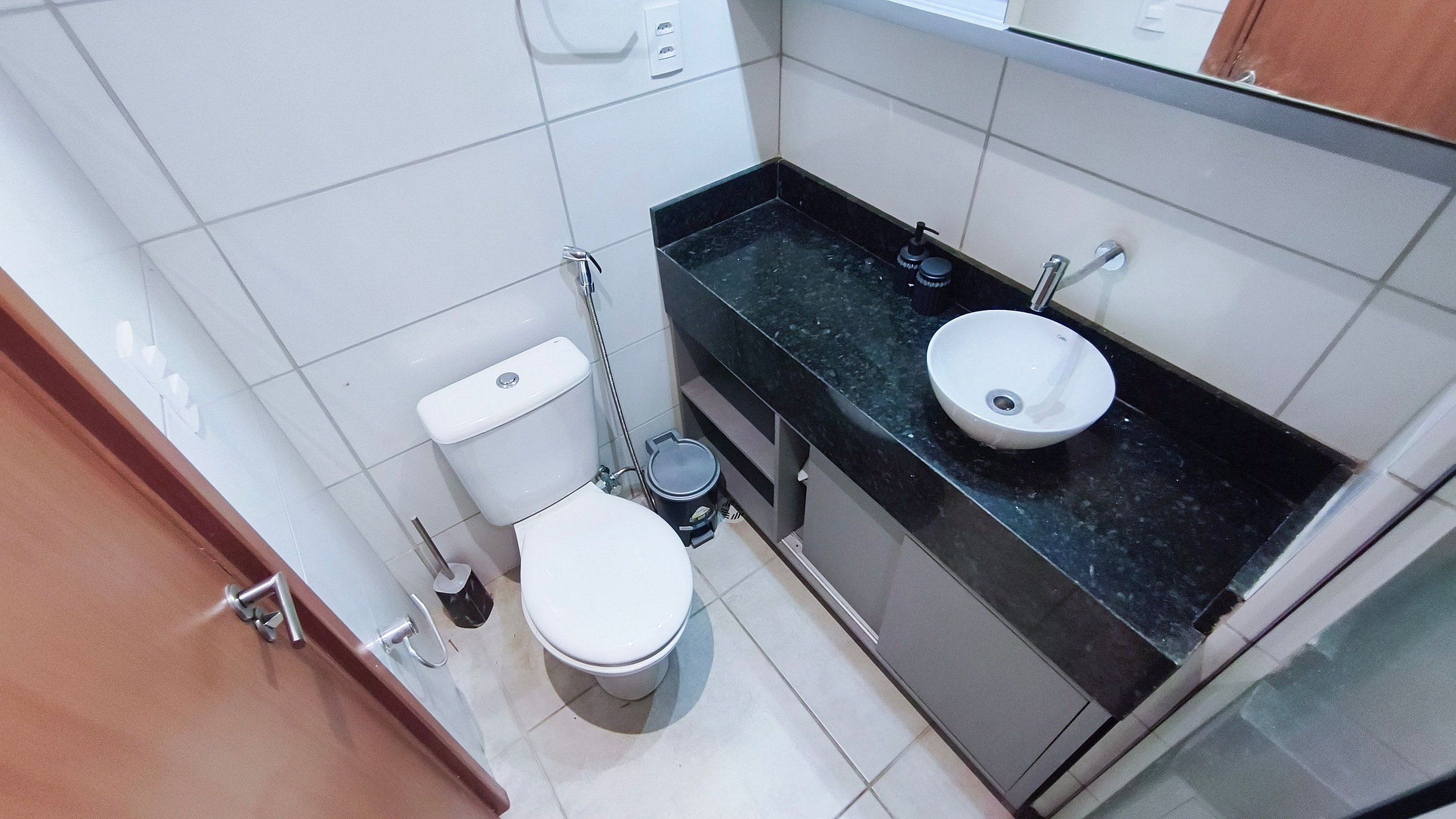 A compact bathroom with a toilet, bidet, and sink.
