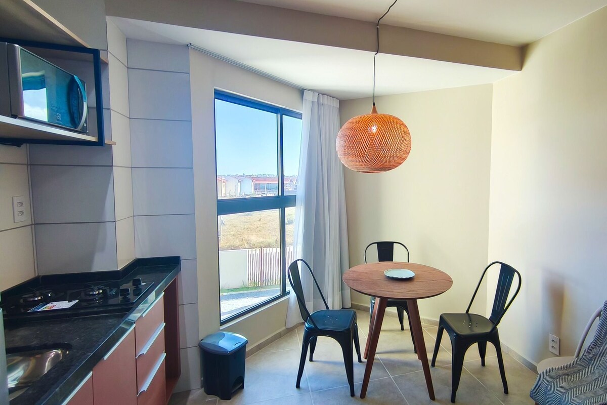 Une cuisine moderne équipée d’un four à micro-ondes, d’une cuisinière et d’un coin repas avec des chaises et une table.