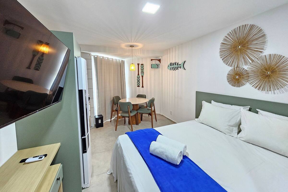 Ein Hotelzimmer mit Bett, Fernseher, Schreibtisch und Essecke.