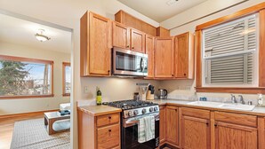 A kitchen with wooden cabinets, a stainless steel stove, and a microwave.