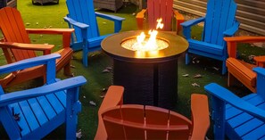 A fire pit surrounded by colorful Adirondack chairs in an outdoor setting. - Skylark Luxe|9BR,7 Suites,Speakeasy,Sauna,Sleeps22 (McGaheysville)