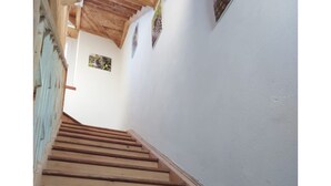 Een houten trap met een witte muur en een plafond.