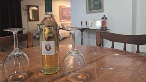 A dining table with a bottle of Cristal Collection wine and three empty wine glasses.