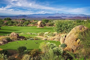A golf course with a clear view of distant mountains, a large rock formation, and a variety of vegetation. - Scottsdale Golf Retreat at Troon North (Scottsdale)