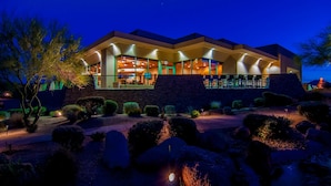 Un edificio moderno con un amplio patio abierto, paredes de piedra y espacios interiores bien iluminados.