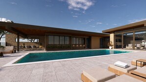 A modern outdoor pool area with a stone wall, wooden deck, and lounge chairs. - Scottsdale Golf Retreat at Troon North (Scottsdale)