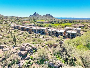 A residential area with modern buildings, a desert landscape, and a mountain in the background. - Scottsdale Golf Retreat at Troon North (Scottsdale)