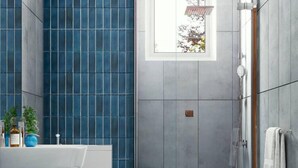 A modern bathroom with a white sink, a glass shower enclosure, and a window providing natural light. - Celestial Villas and Apartments (Negombo)