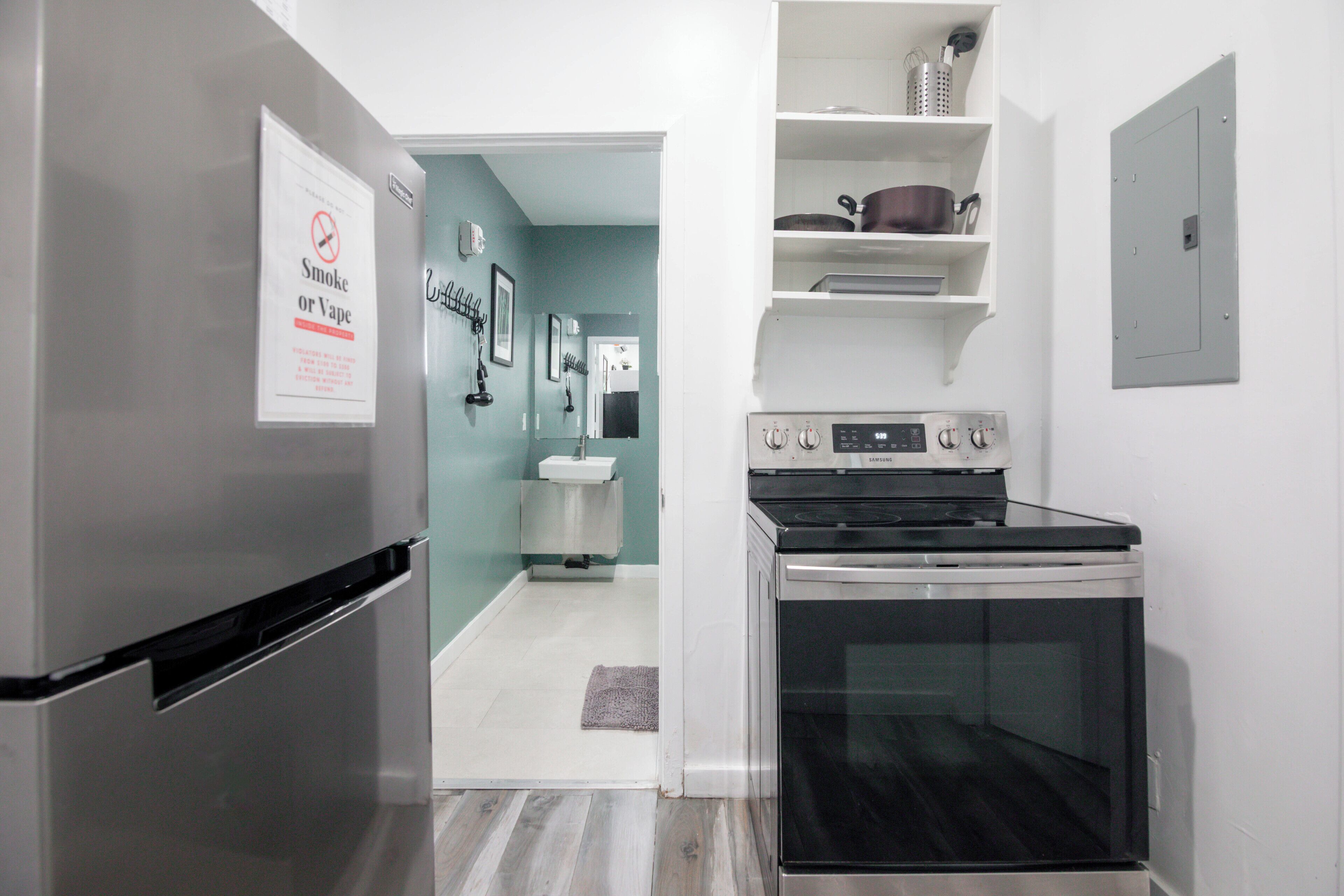 A modern kitchen with a stainless steel refrigerator, a built-in oven, and a white sink.