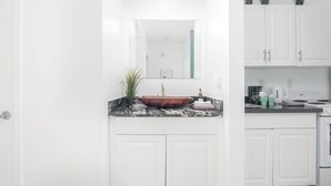 A modern kitchen with white cabinets, a granite countertop, and a stainless steel sink. - Boutique Apartments Flamingo (Miami Beach)