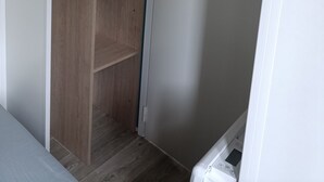 Un dressing avec des étagères en bois et une porte blanche.