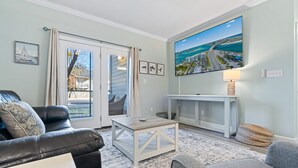 Een woonkamer met een bank, een salontafel en een tv op een dressoir.