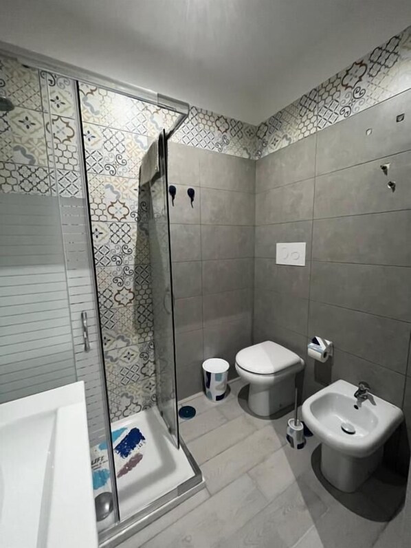 A modern bathroom with a shower, toilet, bidet, and bathtub. - Vicolo 55 (Naples)