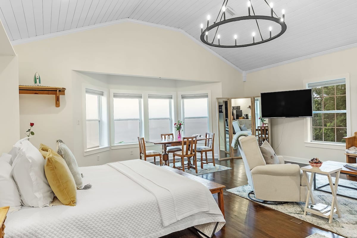 Une chambre spacieuse avec un grand lit, un coin repas et un téléviseur.