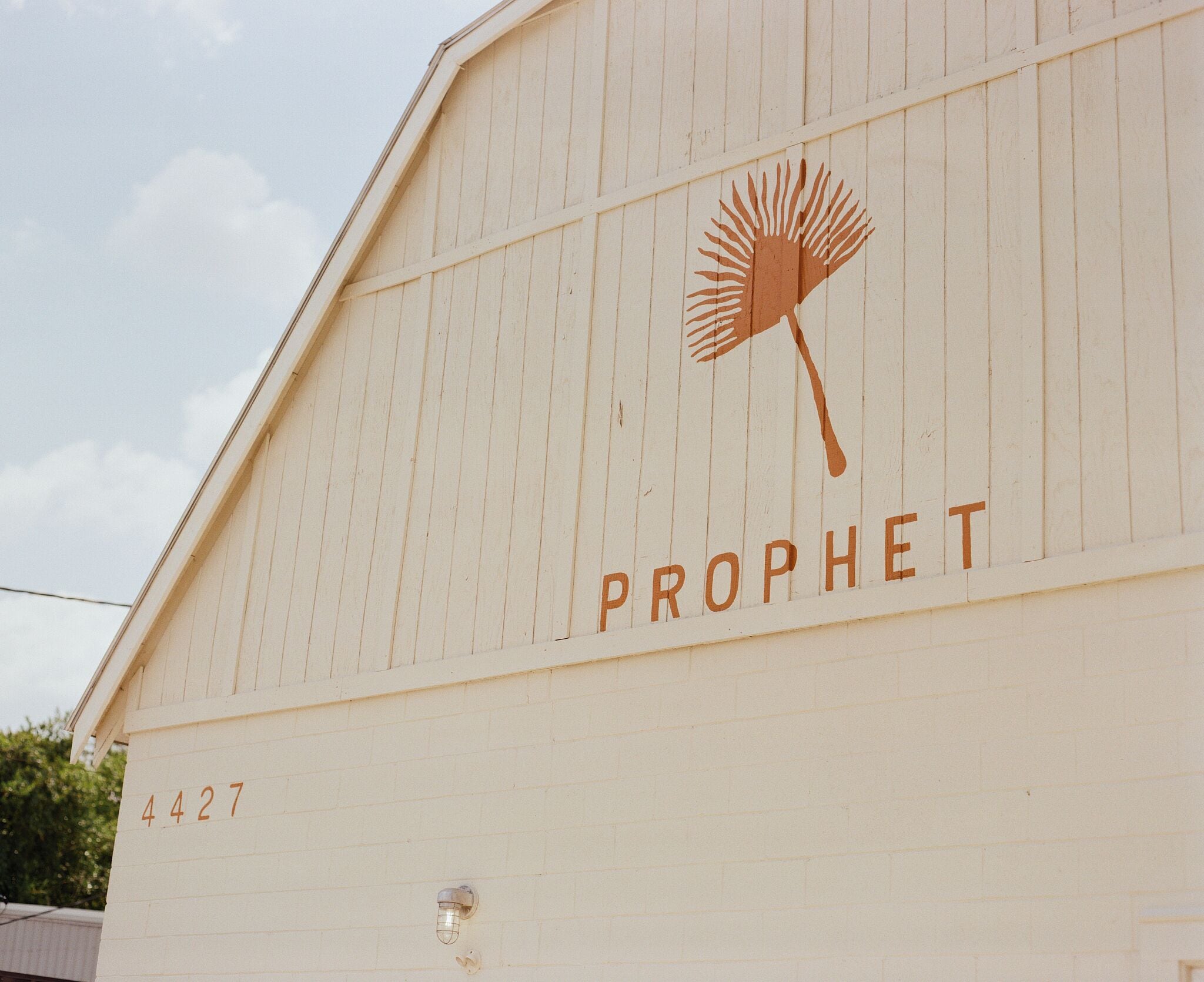A building with the number 4427 and the word "PROPHET" along with a logo of a dandelion.