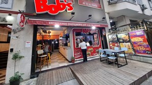 Un camion-restaurant appelé « Bob’s », avec un logo rouge et blanc, qui sert des hamburgers et des milk-shakes.