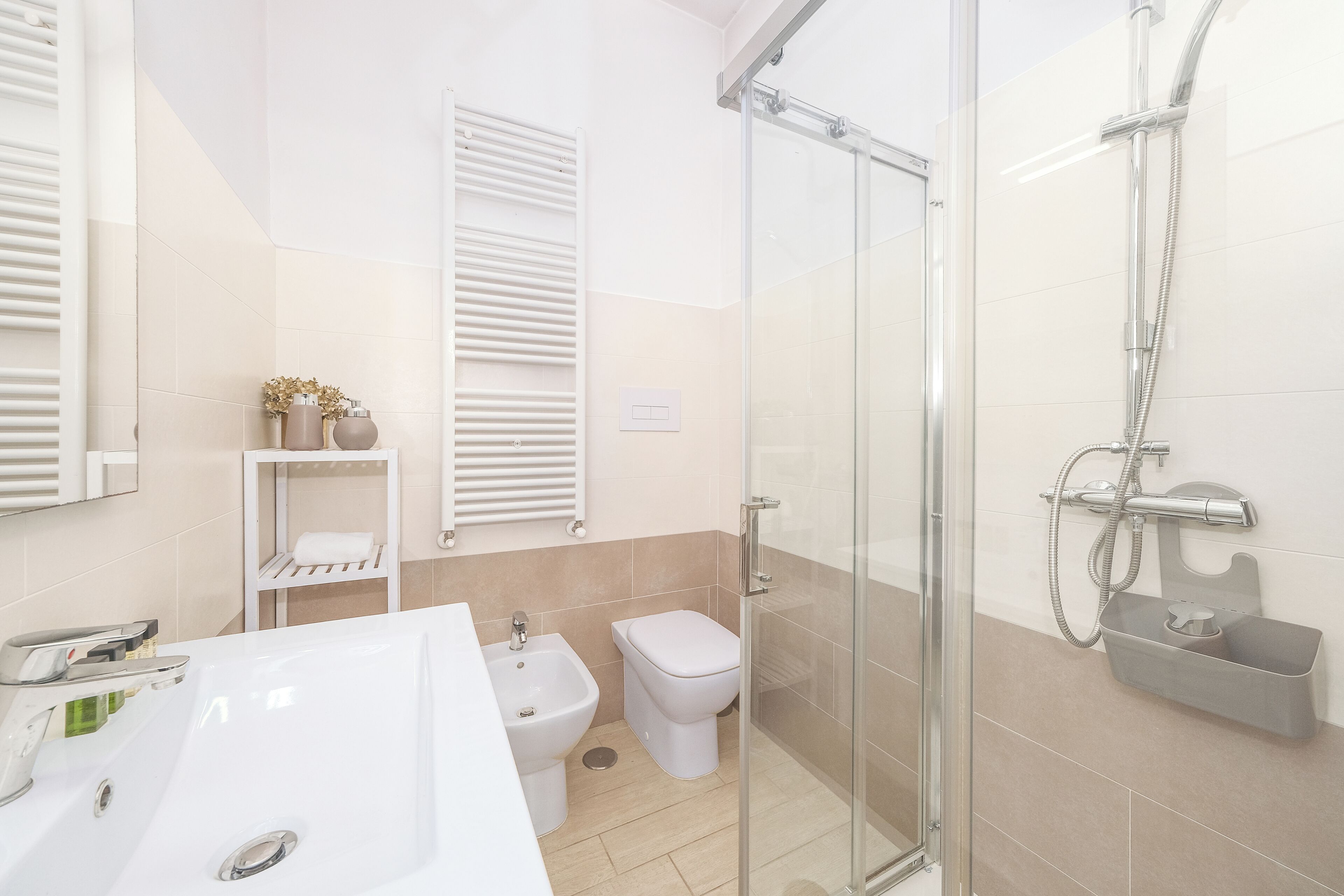 A modern bathroom with a glass shower enclosure, a white sink, and a toilet.