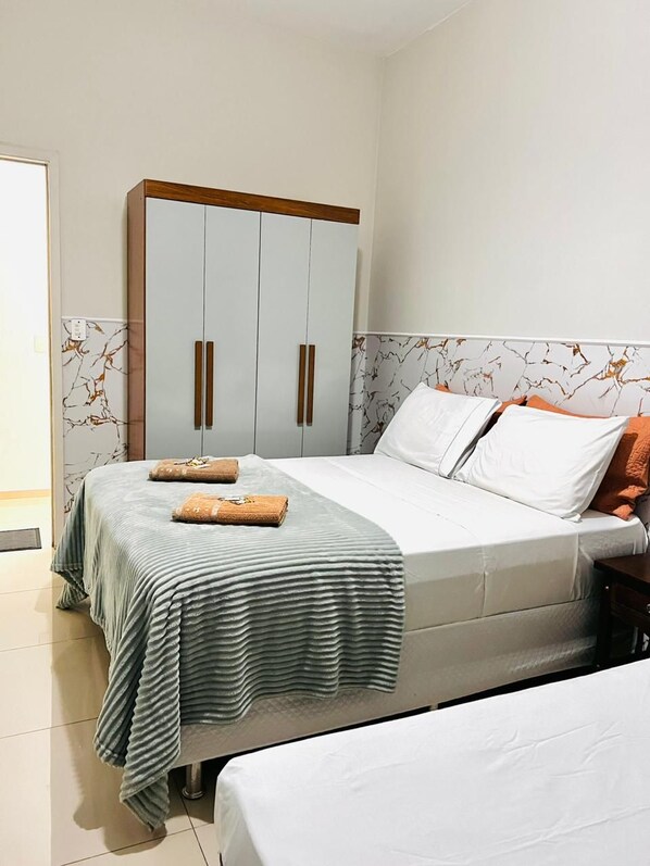 A bedroom with a bed, a wardrobe, and a bathroom. - Hotel Moraes (Mairinque)