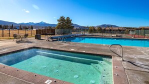 Una piscina con hidromasaje, mobiliario de exterior y vistas a la montaña.