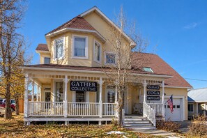 A two-story building with a porch, signs for 'Gather Collective,' 'Massage Yoga,' and 'Skin Care.' - Charming 2BR Fraser Escape – Fireplace, Trails & Resort Nearby! (Fraser)