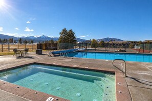 A swimming pool with a view of mountains, a hot tub, and outdoor seating. - Charming 2BR Fraser Escape – Fireplace, Trails & Resort Nearby! (Fraser)