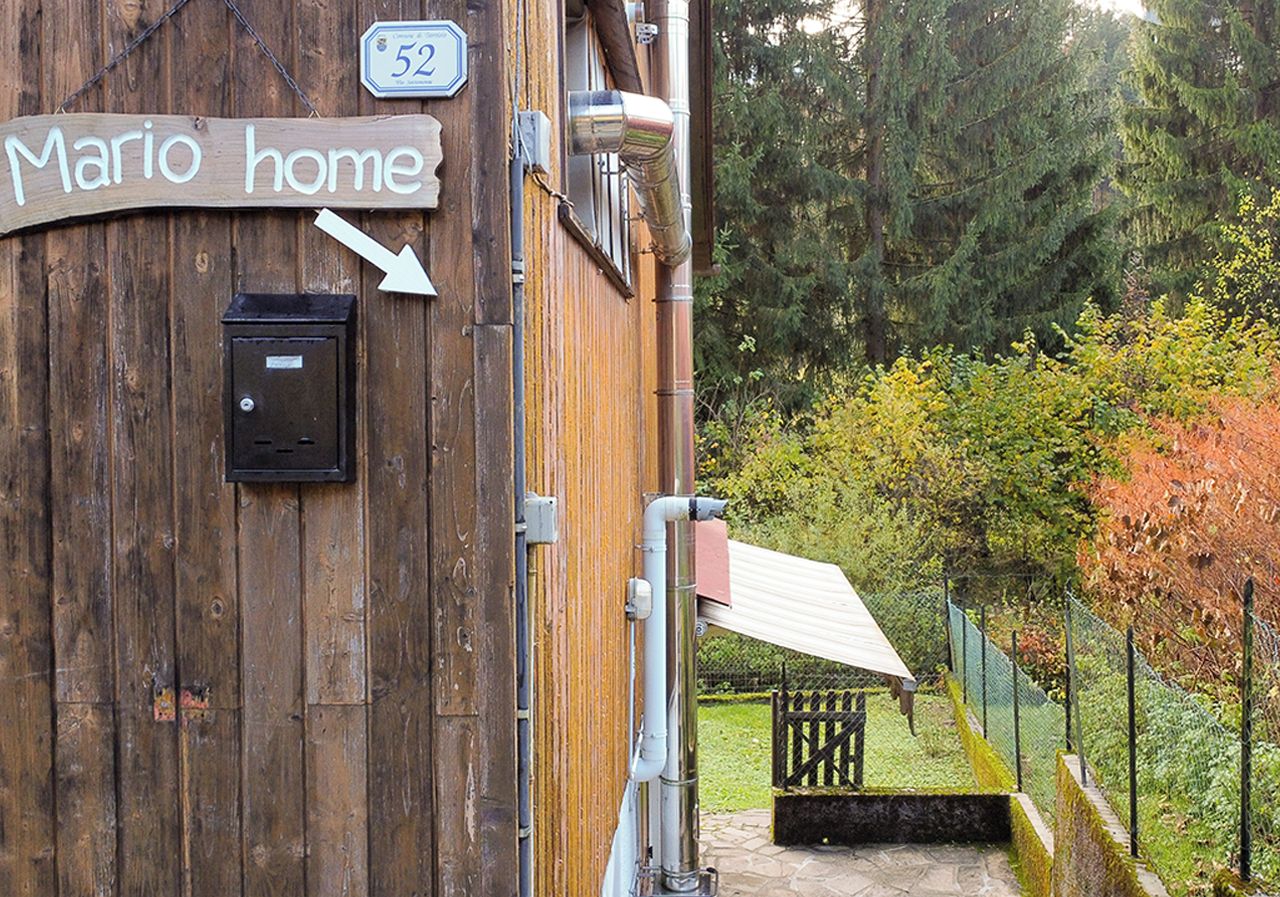 A wooden building with a sign reading "Mario home" and a mailbox.