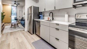 A modern kitchen with stainless steel appliances, white cabinetry, and a built-in oven. - Luxury 1Bed New Build Apt (Oklahoma City)