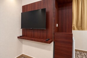 A wall-mounted TV on a wooden shelf in a hotel room. - MG Crown Hotel 1 (Madinah)
