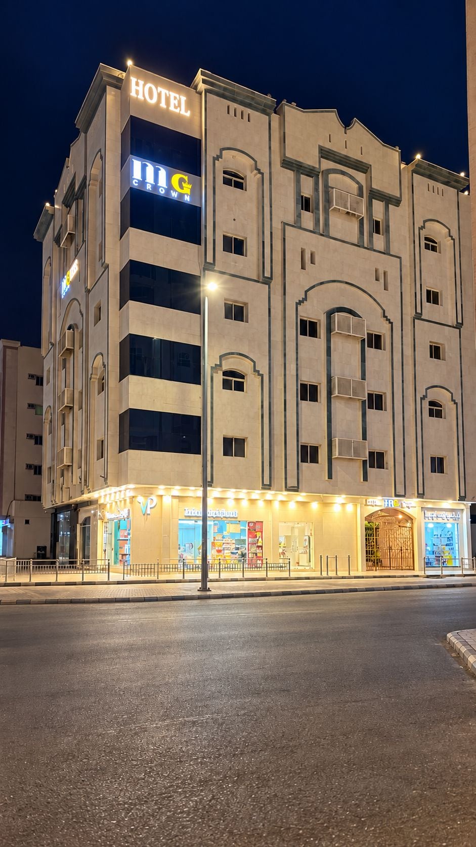 Un hôtel doté d’une enseigne « HÔTEL » bien visible, de nombreux balcons et d’une entrée au niveau du sol avec une signalétique lumineuse.