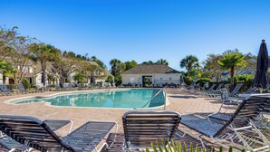 A pool area with lounge chairs and a building in the background. - Golf Getaway w/ Resort Perks in North Myrtle Beach (North Myrtle Beach)