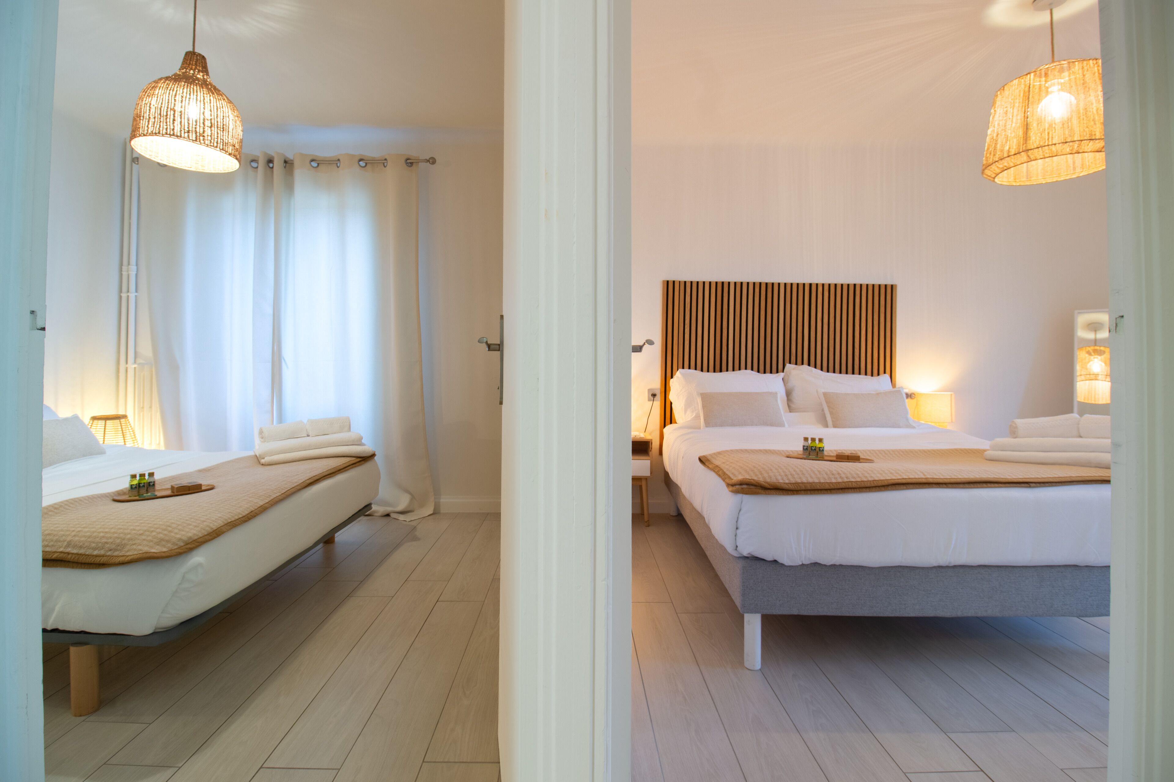 A hotel room with a bed, bedside table, and a hanging light fixture.