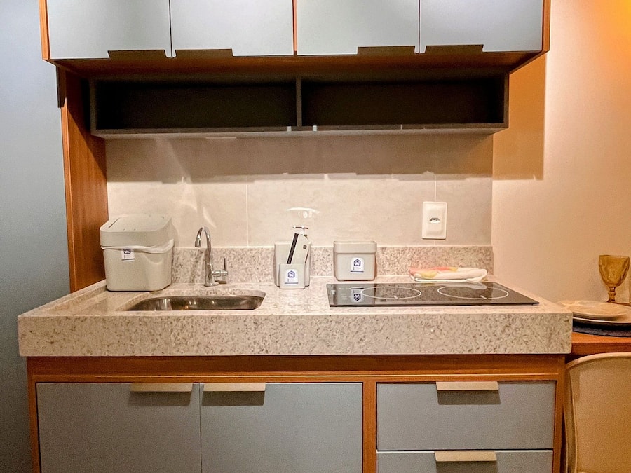 A compact kitchen with a sink, countertop, and built-in cabinets.