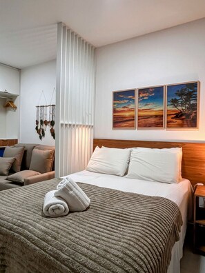 A hotel room with a bed, a sofa, a wall-mounted artwork, and a hanging macrame decoration. - Mahrak Villa - VSH (Ipojuca)