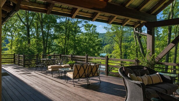 A wooden deck with outdoor furniture, a pergola, and a view of a forested area. - Hawk’s Landing | Hot Tub, Views & Game Room (Banner Elk)